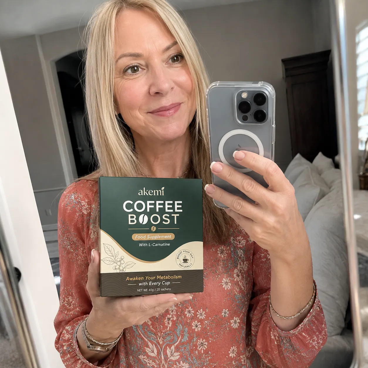 Seller photo: a woman taking a mirror selfie while holding an Akemi Coffee Boost box